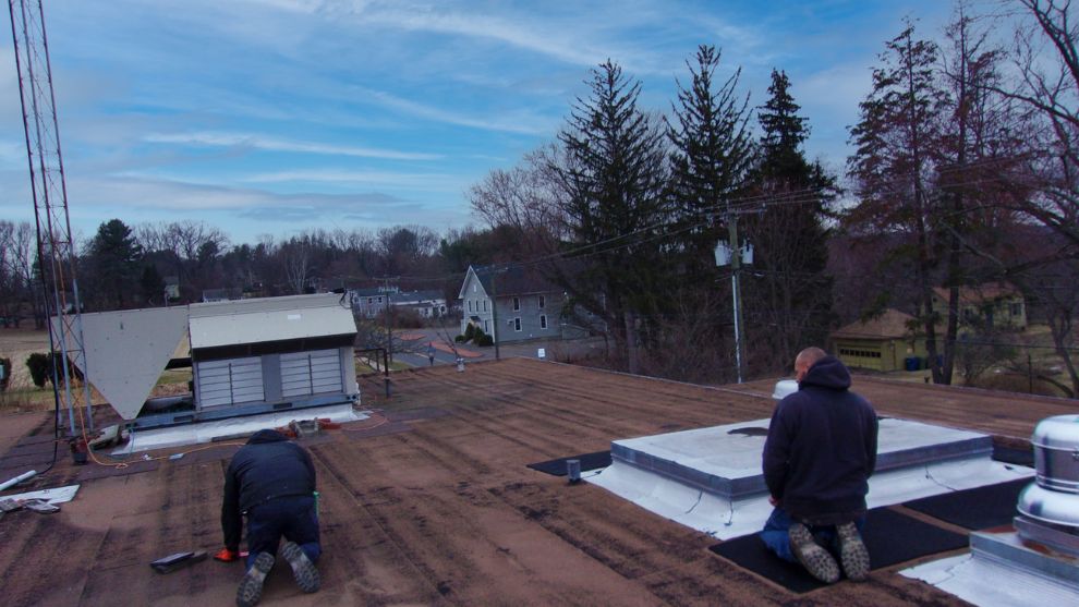 Two workers working on roof