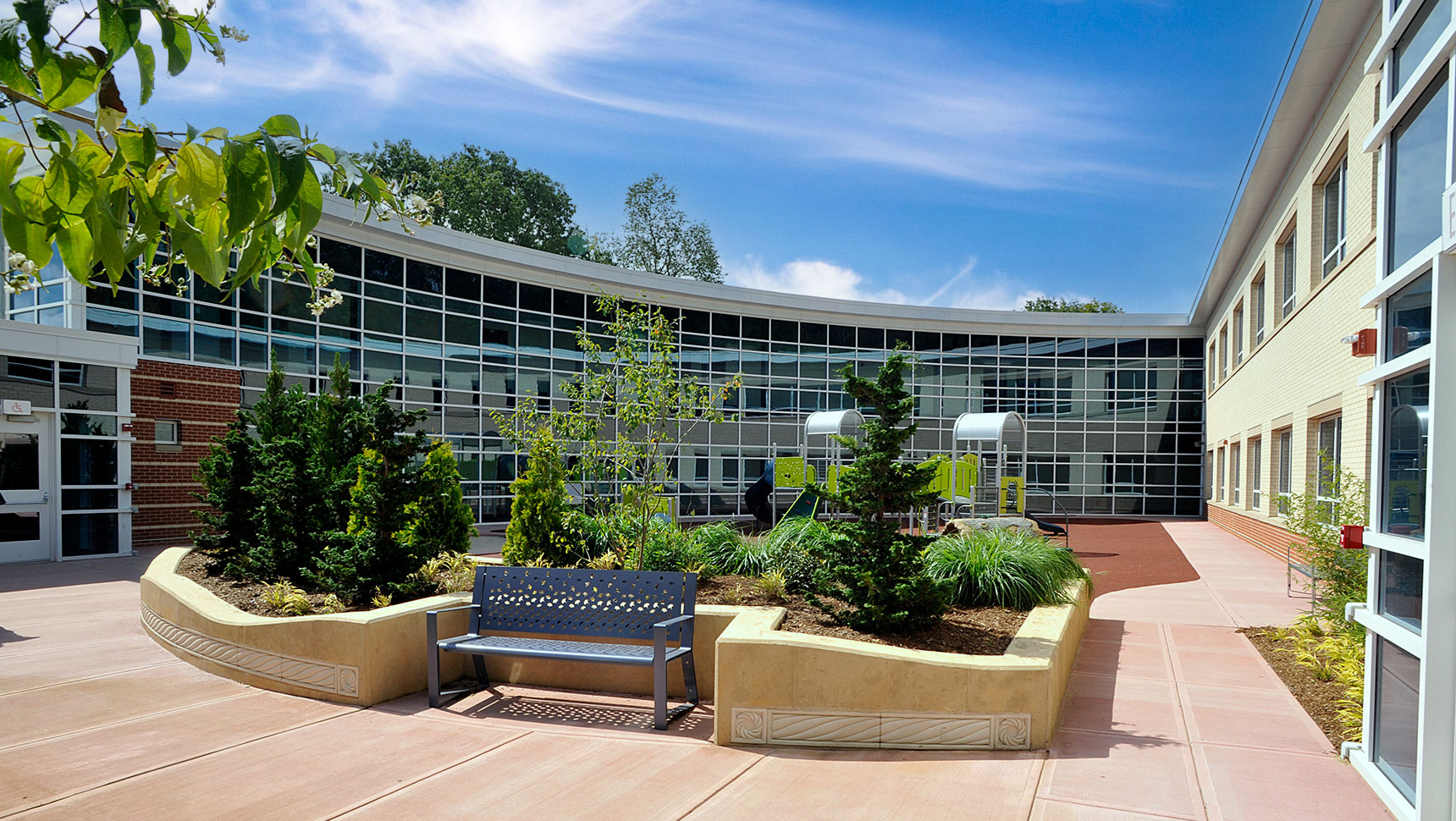 Outside view of school with park bench and playground