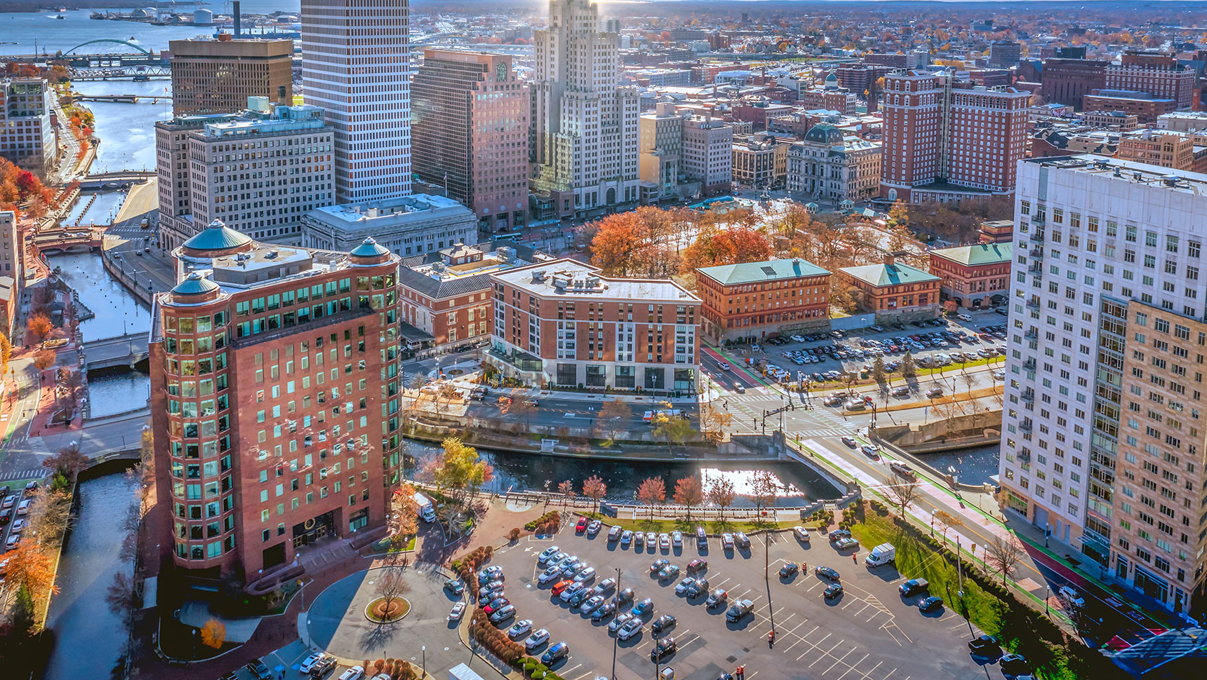 aerial view of city with buildings, streets and river in view