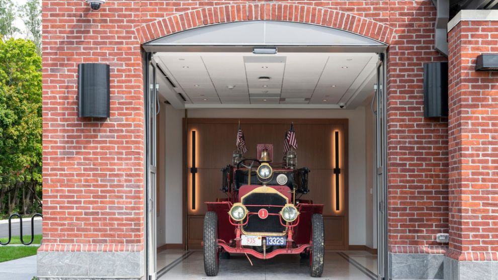 Exterior of firehouse with antique fire truck in garage bay