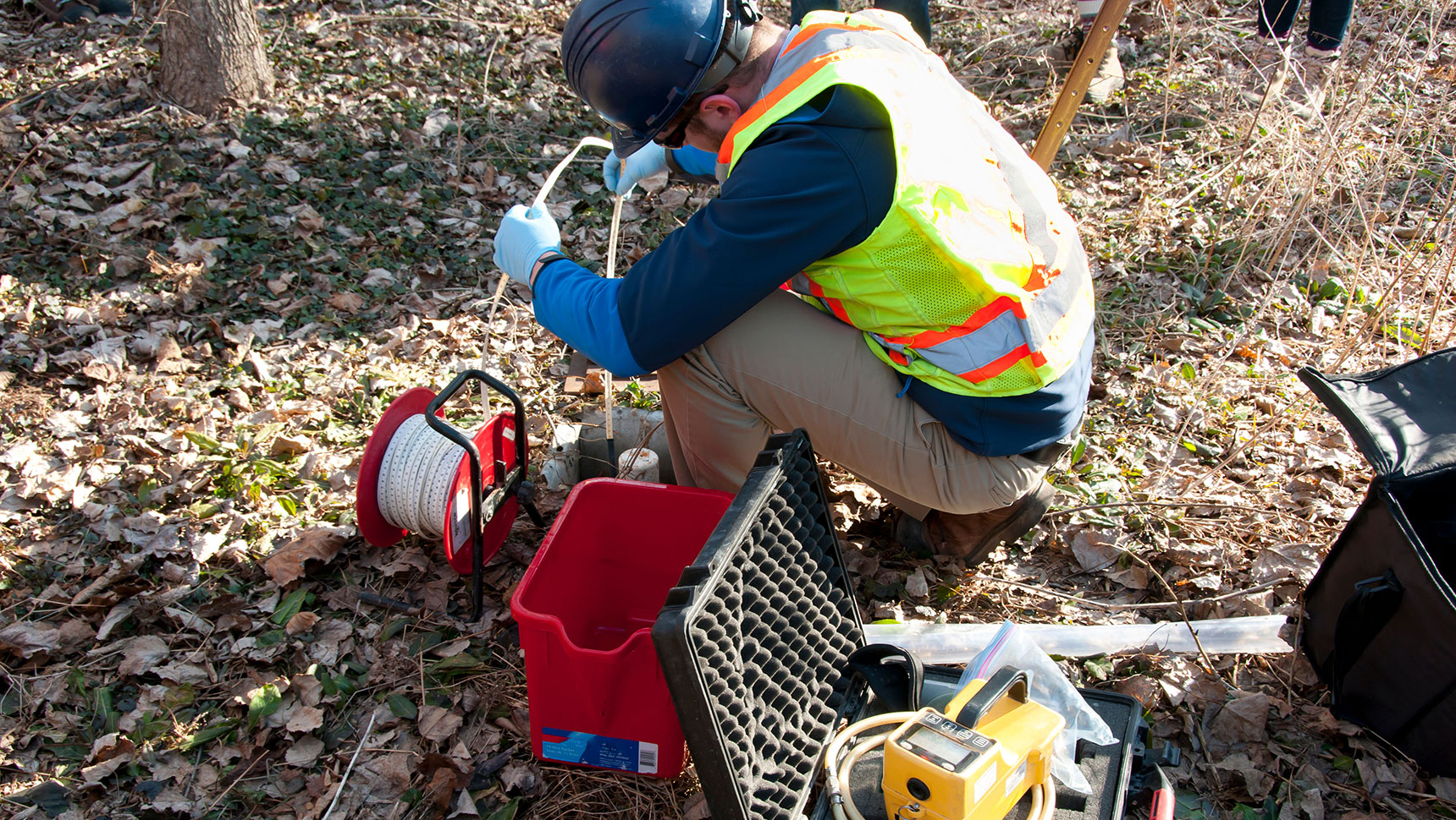 Person with safety vest taking water samples