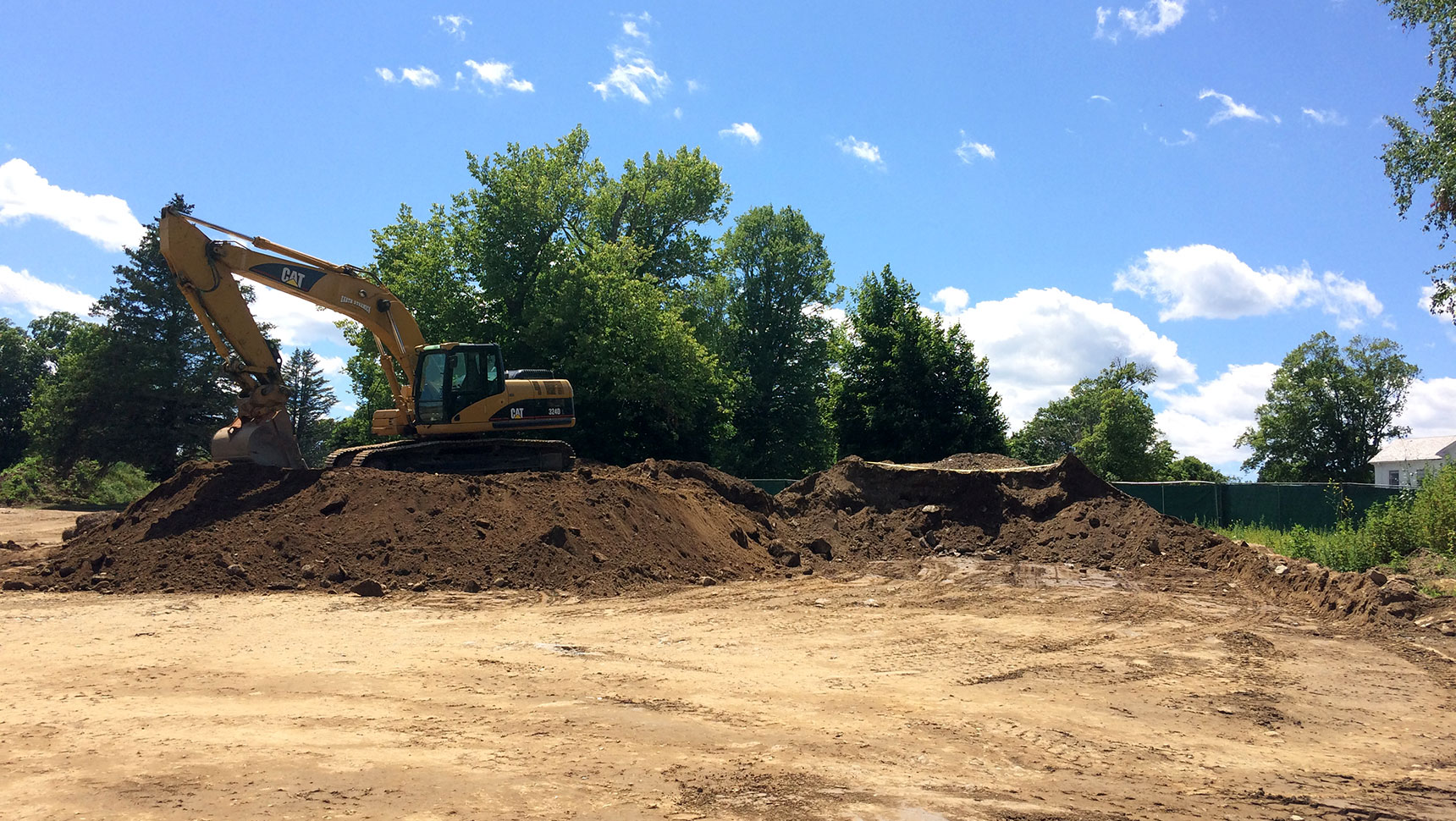 Pile of dirt with an excavator on top