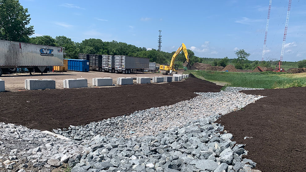 Project site with dirt drainage and excavator