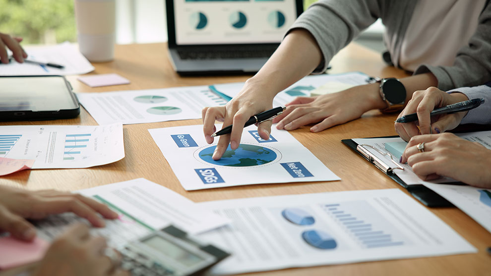 Close up view of someone at a conference table reviewing statistics