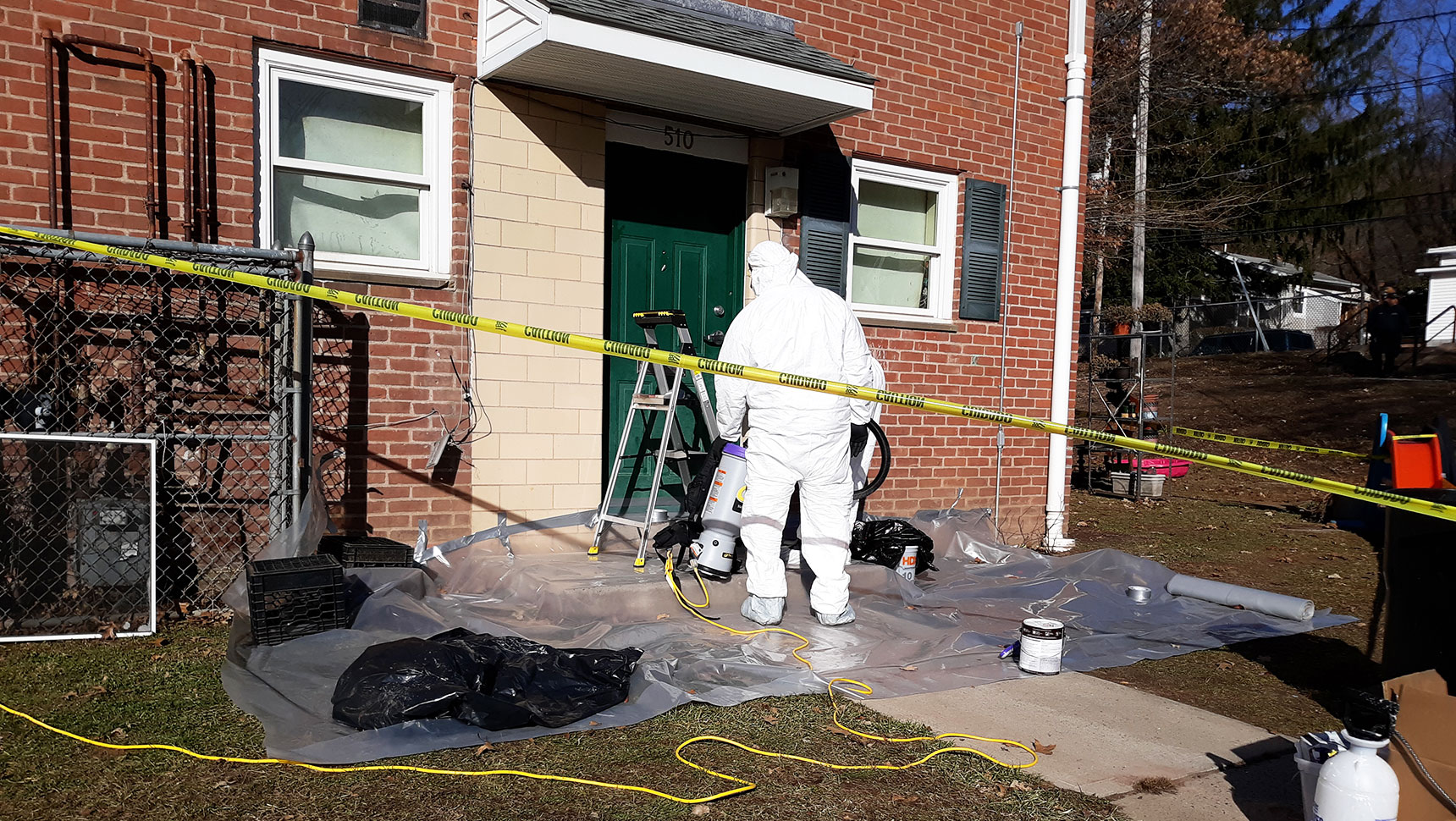 Elm City, person in Tyvek suit working on building