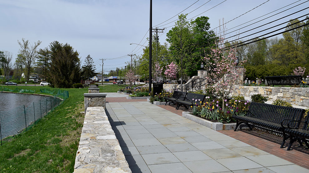 A completed park with benches sidewalk and pond