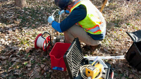 someone performing water sampling with equipment