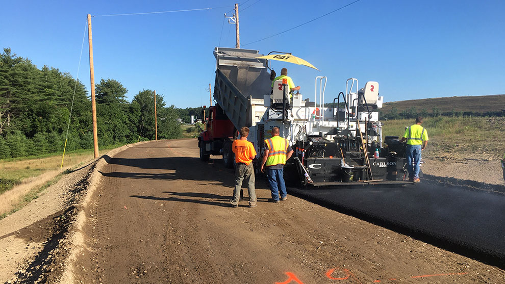 Construction workers laying down pavement