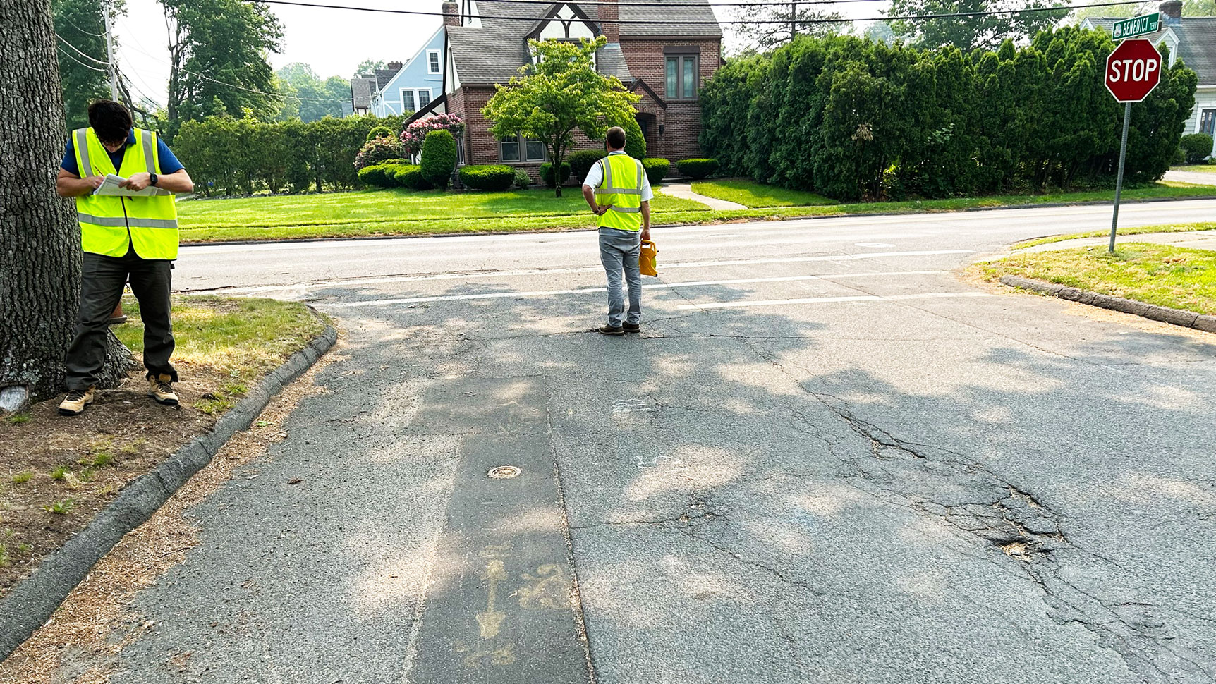 Two people with safety vests on surveying the road