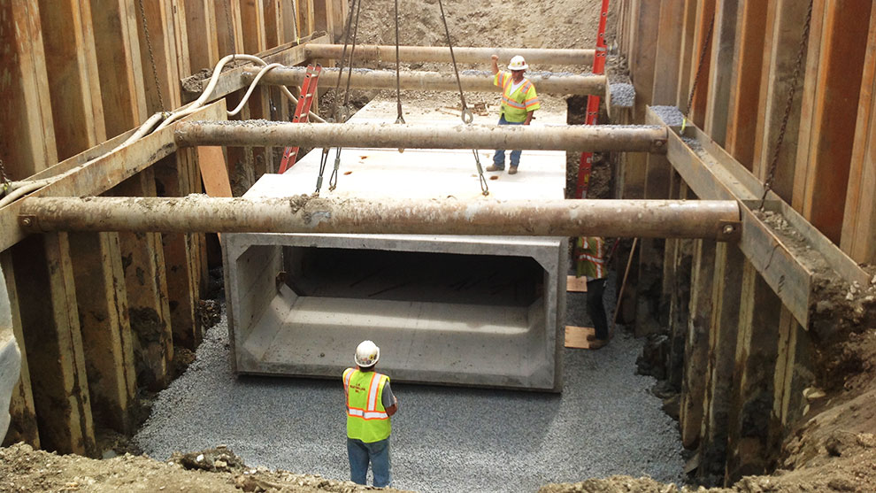 two construction workers placing culvert