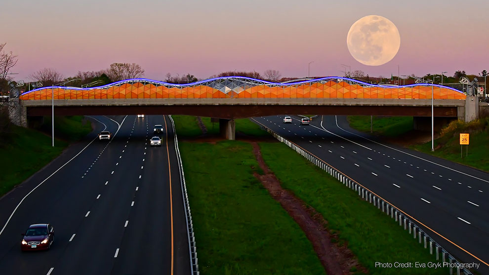 beehive bridge with panels lit and moon rising in the background