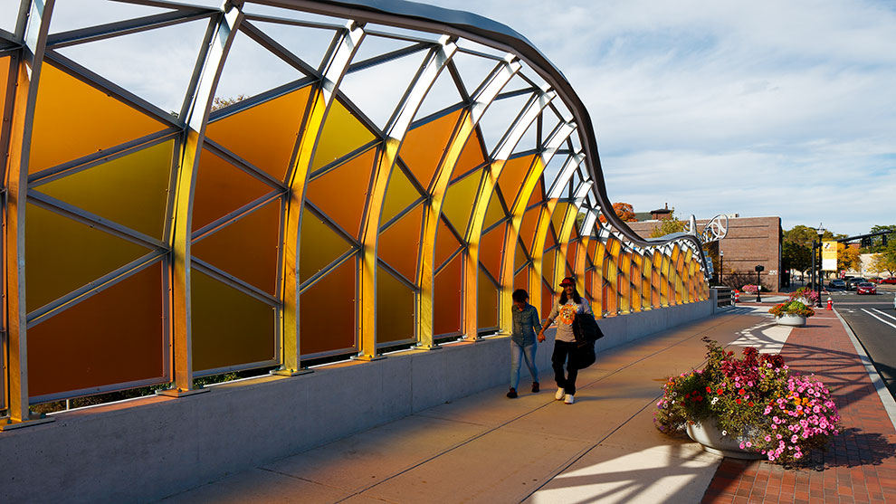 two people walking on bridge