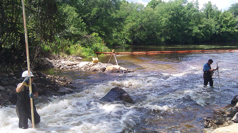 Surveyors standing and surveying in the watershed